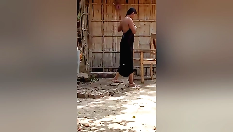 Indian woman bathing in the open field in the village